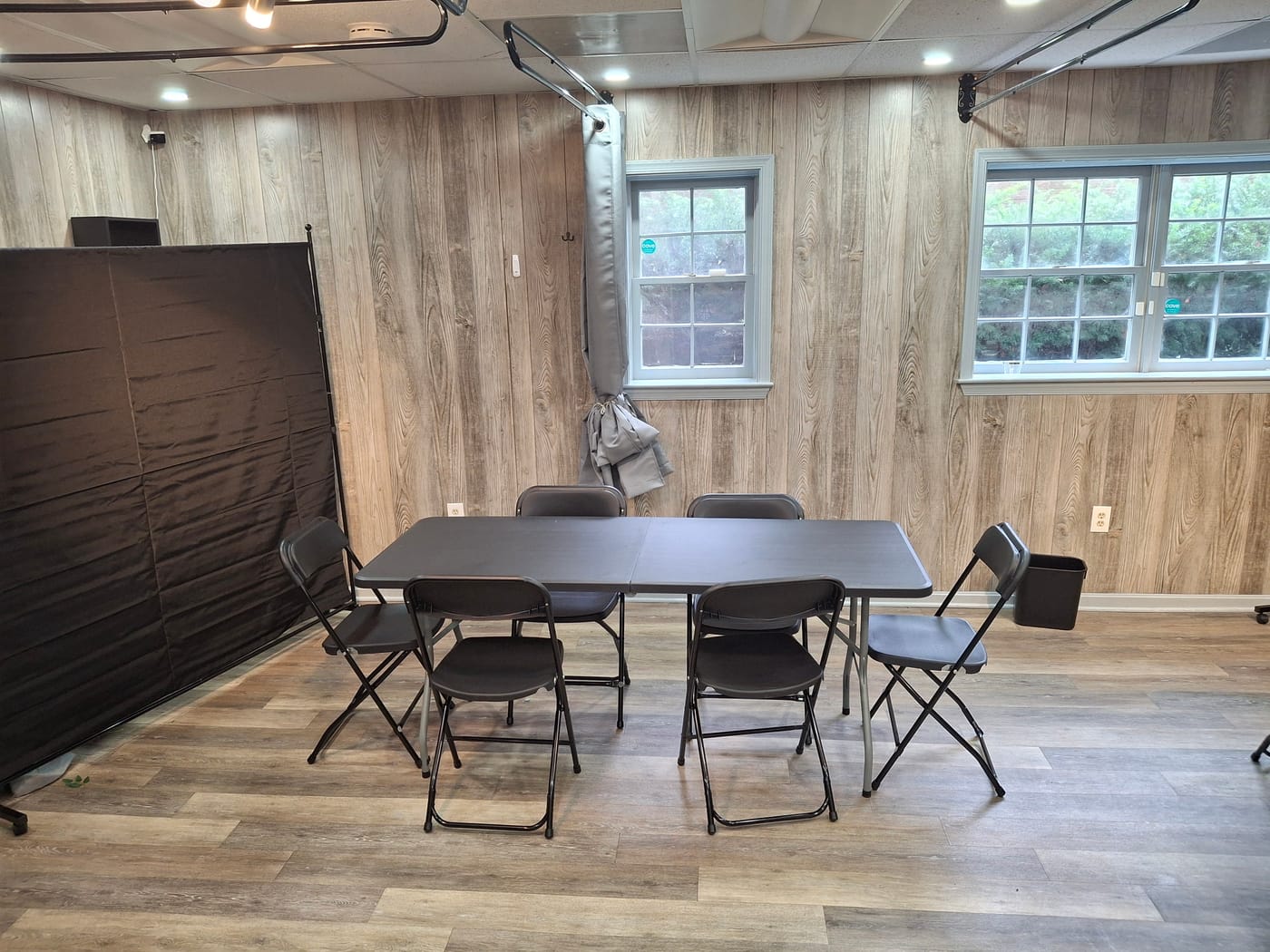 Table and chair setup in the back salon with natural light from the windows and privacy backdrops