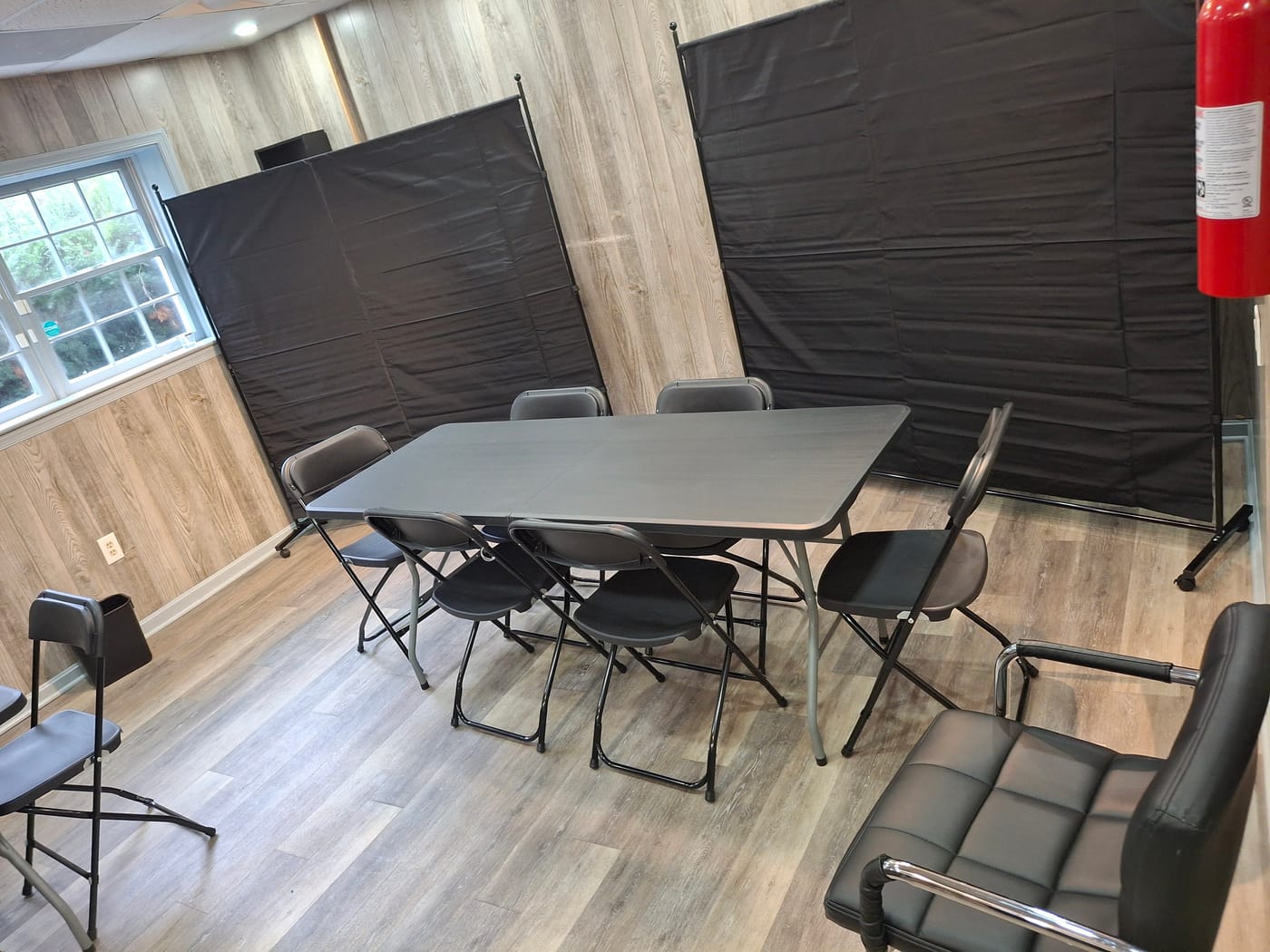 Folding table with six chairs set up in the back salon for a workshop or small group session